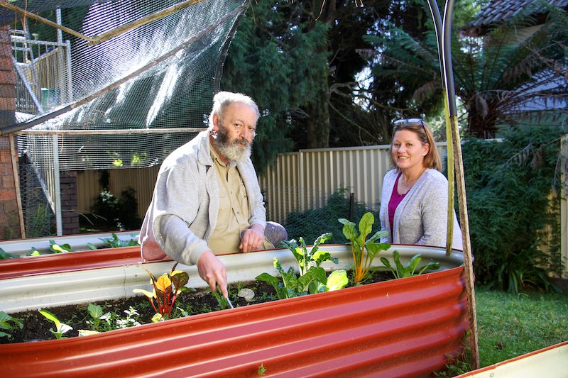 Frank tending to his garden with support worker