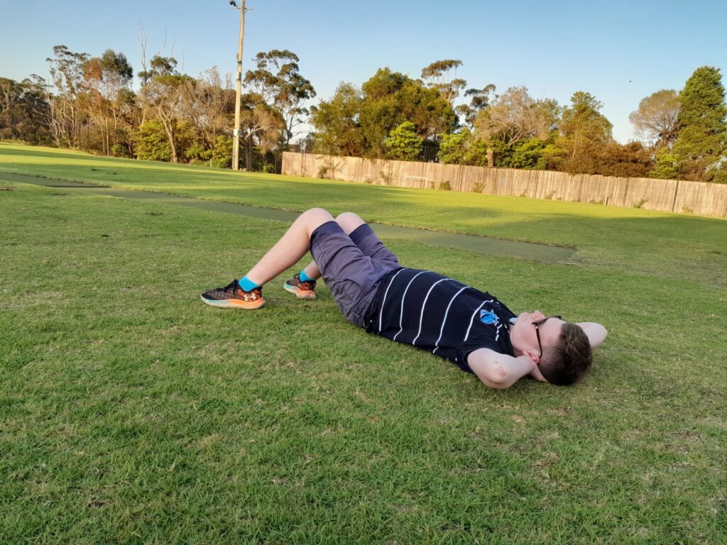 Patrick lying on the grass with his hands behind his head