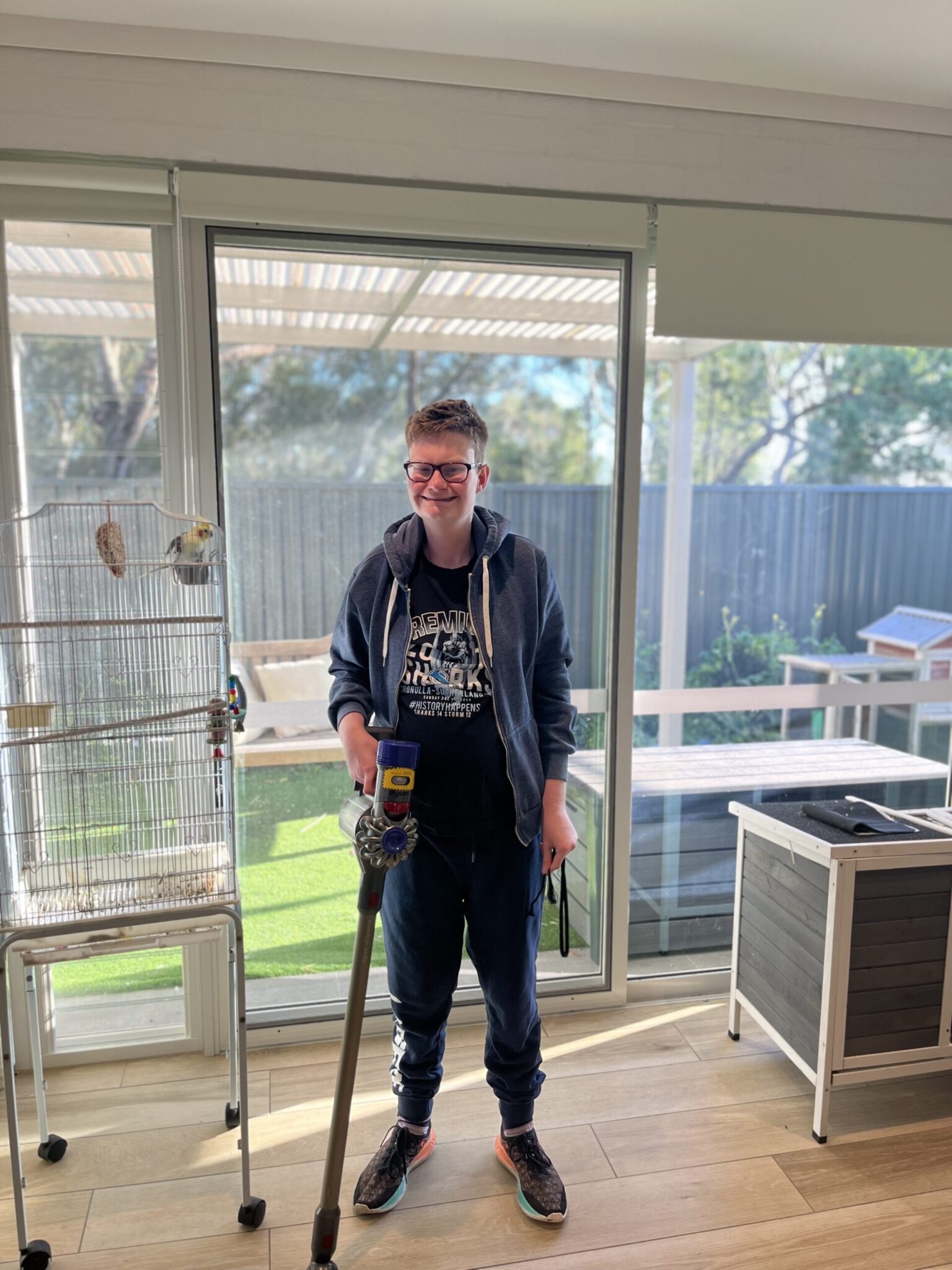 Patrick smiling while doing the vacuuming